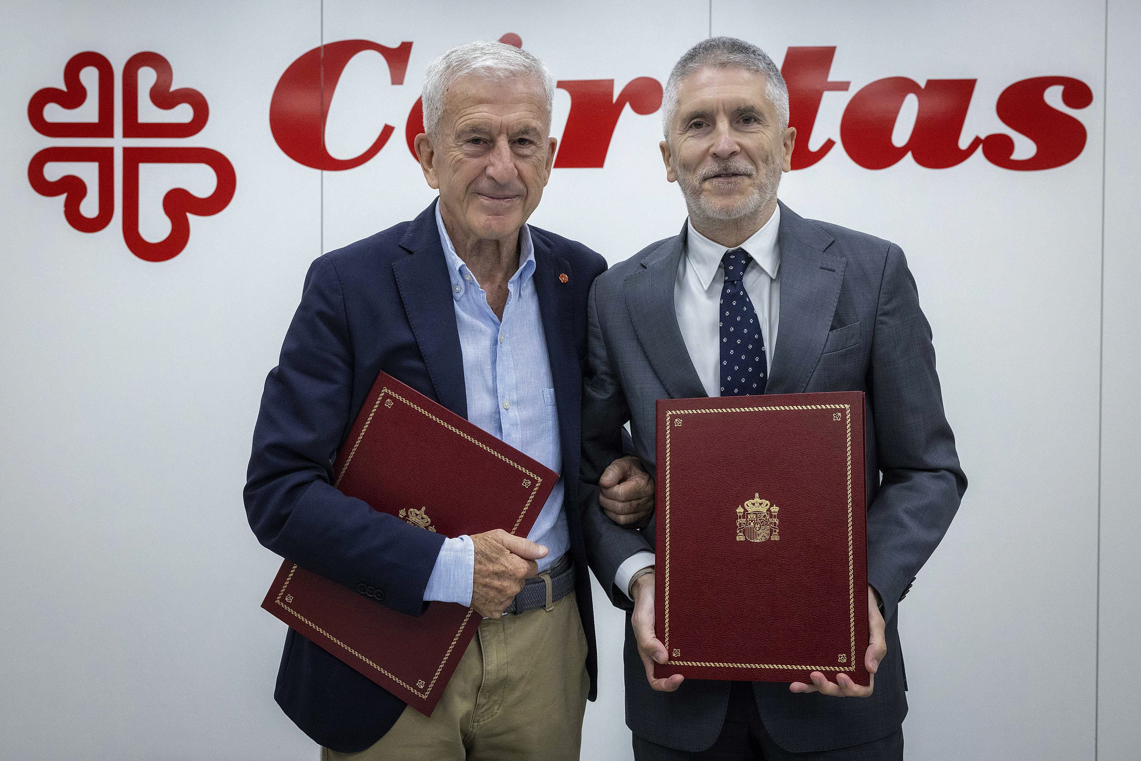 El ministro del Interior y el presidente de Cáritas con el protocolo firmado